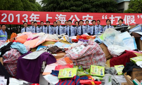 Police officers present seized counterfeit products Wednesday in Pudong New Area. The products have been slated for destruction. City police have cracked 50 criminal rings, shut down 60 dens and detained 350 suspects involved in 600 cases. Photo: Cai Xianmin/GT
