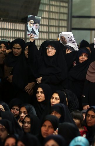 Iranian women hold photos of (from left) late Ayatollah Khomeini, Iran's supreme leader Ayatollah Ali Khamenei and Iranian President Rouhani, while listening to Rouhani delivering a speech on Tuesday. Photo: AFP