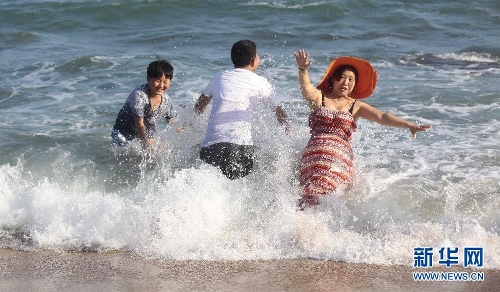 Photo taken on Feb. 11 shows visitors playing on the seashore in Sanya. According to the statistics issued on Feb. 15, by the national holiday tourism office for coordination meeting of inter-ministry and department, the totoal number of people touring 39 major resort and tourist cities of China reached 76,000,000 during this year's seven-day Spring Festival holiday, up 15 percent year on year. And the number of tourists visiting 33 popular scenic spots across China increased by 20 percent year on year. (Source: xinhuanet.com/photo)