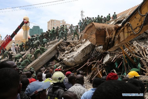 Rescuers search for survivors at the building collapse site in downtown Dar es Salaam, Tanzania, March 29, 2013. A 16-storey building on Friday morning collapsed in Dar es Salaam, with more than 60 people got trapped in the debris. No casualties have been reported as of noon local time. (Xinhua/Zhang Ping)