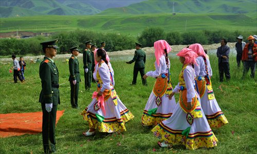 Four dancers walk toward the stage before their performance.
