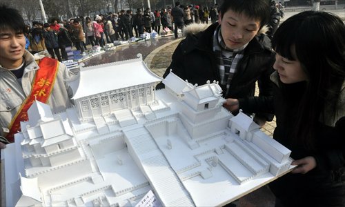 Three students look at a model of part of the Forbidden City during an environmentally friendly construction exhibition held by students from the School of Art at Liaocheng University on their campus in Shandong Province on Sunday. All the models featured in the event were made of recycled materials including wooden boards, chopsticks and paper. Photo: IC