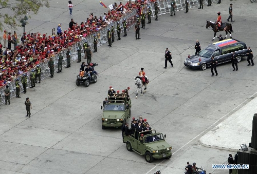 The body of late Venezuelan President Hugo Chavez is carried from the Military Academy to the Mountain Barracks, in the city of Caracas, capital of Venezuela, on March 15, 2013. Venezuelans honored late President Hugo Chavez, before his remains were transfered to the Mountain Barracks, where he will rest inside a glass case. Venezuelan President died on March 5, after struggling with cancer for two years. (Xinhua/AVN) 