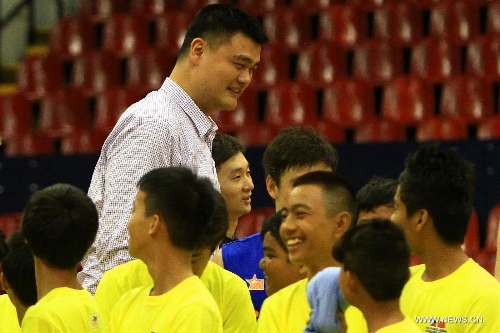 Former Chinese basketball superstar Yao Ming (Back) greets children during a basketball clinic in Pasig City, the Philippines, May 5, 2013. Yao and his Shanghai Sharks are in Manila on a friendly visit. They will attend two exhibition games respectively with the Smart Gilas Team and the Philippine Basketball Association (PBA) Selection. (Xinhua/Rouelle Umali) 
