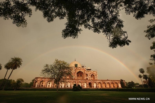Two rainbows are seen above Humayun's Tomb in New Delhi, capital of India, May 12, 2013. Humayun's Tomb, located in east New Delhi, was built in 1569 to 1570 by Humayun's widow. As a precursor to the Taj Mahal, it stands on a platform of 12,000 square meters and reaches a height of 47 meters. The earliest example of the Persian influence in Indian architecture, the tomb itself is in the center of a large garden, surrounded by 12 hectares of gardens with pools joined by channels. The tomb brought Persian style to Delhi, but the two-tone combination of red sandstone and white marble is local, which shows the merging of different cultures. Humayun's Tomb was inscribed on the World Heritage List by the United Nations Educational, Scientific and Cultural Organization in 1993. (Xinhua/Zheng Huansong) 