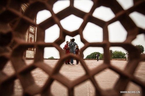 Tourists visit Humayun's Tomb in New Delhi, capital of India, May 12, 2013. Humayun's Tomb, located in east New Delhi, was built in 1569 to 1570 by Humayun's widow. As a precursor to the Taj Mahal, it stands on a platform of 12,000 square meters and reaches a height of 47 meters. The earliest example of the Persian influence in Indian architecture, the tomb itself is in the center of a large garden, surrounded by 12 hectares of gardens with pools joined by channels. The tomb brought Persian style to Delhi, but the two-tone combination of red sandstone and white marble is local, which shows the merging of different cultures. Humayun's Tomb was inscribed on the World Heritage List by the United Nations Educational, Scientific and Cultural Organization in 1993. (Xinhua/Zheng Huansong) 