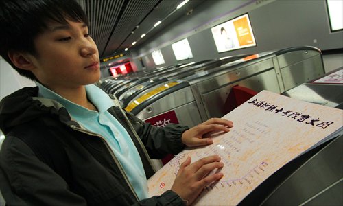 A visually impaired man Thursday reads a subway map designed for the blind by Shanghai metro authorities. The map is supposed to make it easier for the blind to navigate the subway. Photo: Xinhua