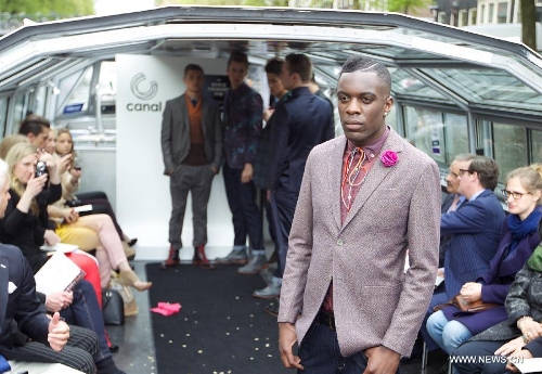 A model presents a creation on a canal boat in Amsterdam, the Netherlands, on May 22, 2013. The event