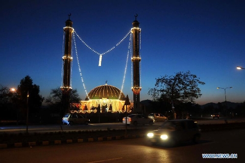 Vehicles drive past the illuminated mosque during celebrations ahead of Eid-e-Milad-un-Nabi, marking the birth anniversary of the Islam's Prophet Mohammed, in northwest Pakistan's Peshawar on Jan. 24, 2013. (Xinhua Photo/Umar Qayyum) 