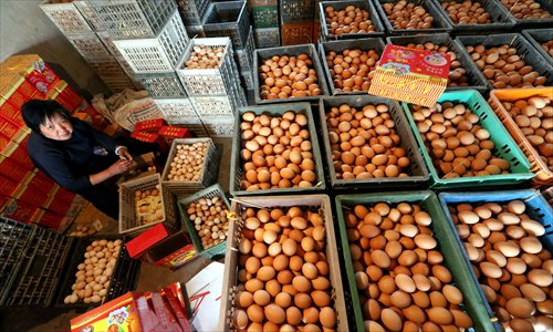A chicken breeder in Pudong New Area packs eggs Monday. The breeder's farm in Nanhui area has raised more than 12,000 chickens to produce eggs. The breeder loses 15 yuan ($2.42) on every crate of eggs she sells due to the drop in prices that has occurred since the H7N9 bird flu was first reported. She has lost all of the money she has made over the past three years. Photo: Yang Hui/GT