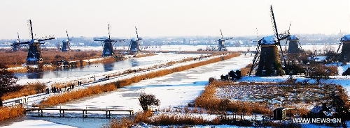  Windmills are seen after snowfall in Kinderdijk, west of the Netherlands, Jan. 16, 2013. The small town of Kinderdijk is known for its 19 well-preserved windmills which were built around 1740. Every year about 500,000 tourists visit Kinderdijk, a UNESCO World Heritage site since 1997. (Xinhua/Robin Utrecht) 
