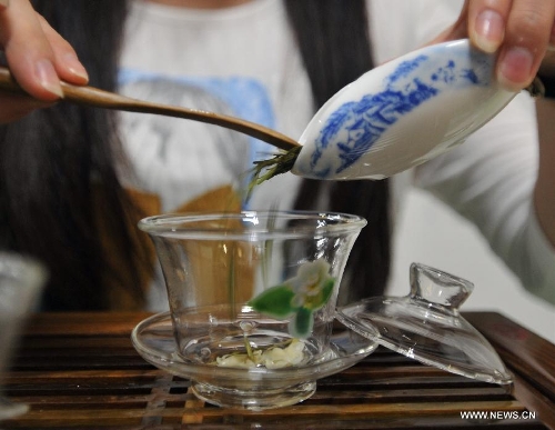 An exhibitor prepares tea for customers at the 6th Guangxi Nanning Spring Tea Fair in Nanning, capital of south China's Guangxi Zhuang Autonomous Region, April 29, 2013. The five-day fair kicked off on Sunday. (Xinhua/Lu Boan) 