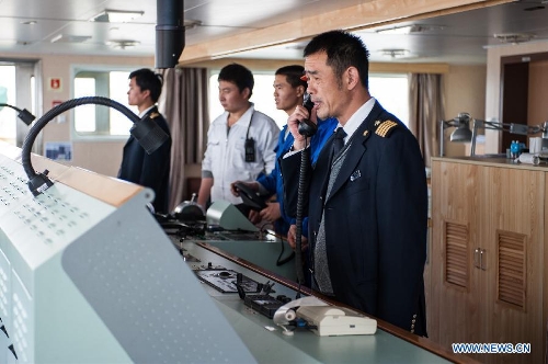 Wang Lianmiao (1st R) contacts nearby ships via high frequency radio aboard the Maple Star on the Yangtze River in east China's Jiangsu Province, April 24, 2013. (Xinhua/Li Mangmang) 