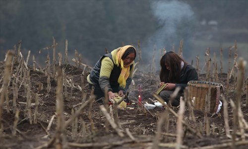 Villagers light candles during a memorial service for their loved ones who were killed by a landslide Friday in Zhenxiong county, Yunnan Province that claimed the lives of 46 people. Photo: CFP