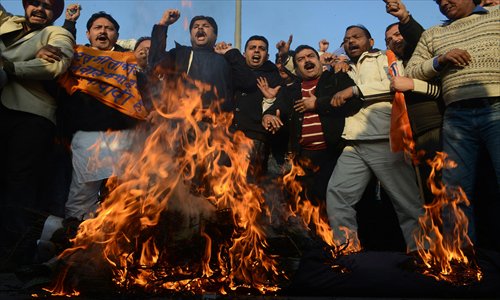 Activists from India's main opposition Bharatiya Janata Party (BJP) burn an effigy of  Indian Home Minister Sushilkumar Shinde as they demand his resignation for alleging that the BJP and the Rashtriya Swayamsevak Sangh (RSS) were behind attacks on non-Hindus during a demonstration in Amritsar on Thursday. Photo: AFP 