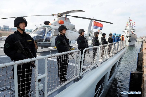 Chinese Navy special force members stand on the deck of a missile frigate 