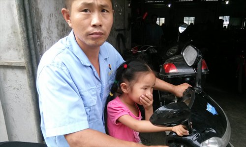 A girl covers her nose while passing a factory near the No.9 Primary School of Beibaixiang township in Yueqing, Zhejiang Province, on September 6. Photo: CFP