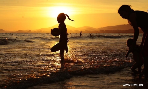 People play along the seaside in Sanya, south China's Hainan Province, May 20, 2013. (Xinhua/Chen Wenwu) 