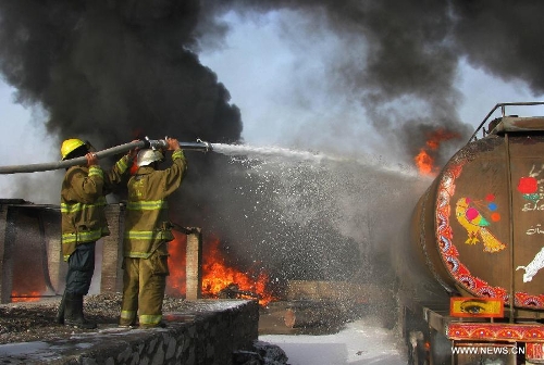 Firefighters work to extinguish fire at a parking lot where five oil trucks caught fire in Jalalabad, capital city of eastern Afghan province of Nangarhar on May 20, 2013. At least one person was killed in the fire on Monday afternoon. Police officials ruled out involvement of militants in the incident. (Xinhua/Tahir Safi) 