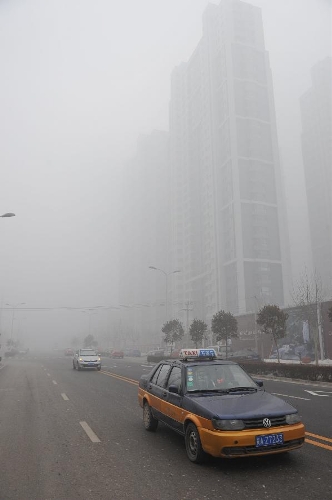 Vehicles run on a road in fog-shrouded Shijiazhuang, capital of north China's Hebei Province, Feb. 17, 2013. (Xinhua/Zhu Xudong) 