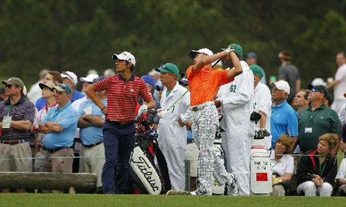 China's Guan Tianlang (Front, R) competes during the second round of the 2013 Masters golf tournament at the Augusta National Golf Club in Augusta, Georgia, the United States, April 12, 2013. Guan shot a three-over par 75 Friday and stood at four-over 148 after 36 holes. (Xinhua/Hunter Martin/Augusta National) 
