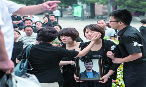 Qiu Yan holds her husband's portrait at his funeral in Babaoshan funeral home Wednesday. Photo: Li Hao/GT
