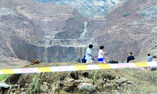 People walk past the Shenjiakeng Reservoir in Daishan county, Zhejiang Province, which ruptured earlier this month.  Eleven people were killed in the ensuing flooding caused by the breach. Photo: CFP