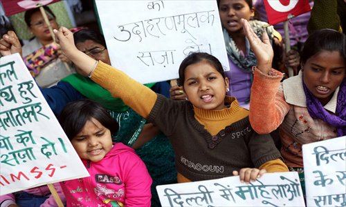 Indian women activists and children shout slogans Tuesday condemning a recent act of alleged gang rape of a 23-year-old student on a city bus, in New Delhi, India. According to a media report on Sunday, the woman was raped by at least seven men inside a bus and later thrown out of the moving bus along with her male friend. Photo: CFP