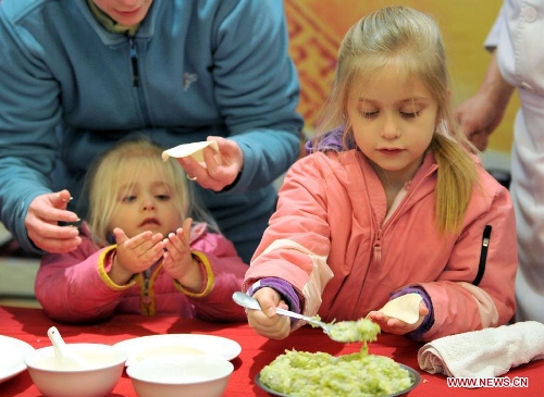 Children of an overseas student learn to make dumplings in an activity to celebrate the Chinese New Year at the Nanjing Agricultural University in Nanjing, capital of east China's Jiangsu Province, Feb. 4, 2013. More than 50 overseas students from over 20 countries and regions experienced Chinese traditional cultural activities with local students. (Xinhua)&nbsp; 