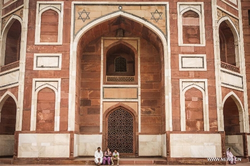 Tourists visit Humayun's Tomb in New Delhi, capital of India, May 12, 2013. Humayun's Tomb, located in east New Delhi, was built in 1569 to 1570 by Humayun's widow. As a precursor to the Taj Mahal, it stands on a platform of 12,000 square meters and reaches a height of 47 meters. The earliest example of the Persian influence in Indian architecture, the tomb itself is in the center of a large garden, surrounded by 12 hectares of gardens with pools joined by channels. The tomb brought Persian style to Delhi, but the two-tone combination of red sandstone and white marble is local, which shows the merging of different cultures. Humayun's Tomb was inscribed on the World Heritage List by the United Nations Educational, Scientific and Cultural Organization in 1993. (Xinhua/Zheng Huansong) 