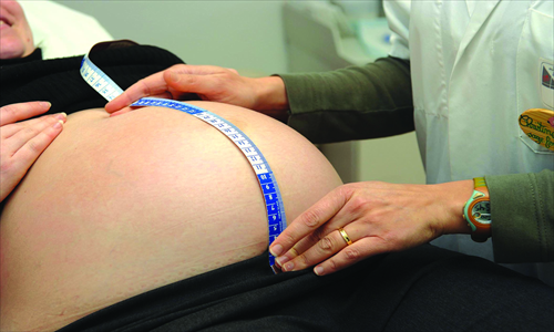 Many doctors recommend women planning children to give birth before 30 for health reasons, but motherhood can conflict with personal and professional ambitions. 
Photos: IC, CFP