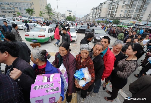 Residents queue to get life supplies at a temporary shelter site in Lushan County of Ya'an City, southwest China's Sichuan Province, April 21, 2013. Several temporary shelter sites can be seen in Lushan County and the life supplies in these shelter sites are sufficient. A 7.0-magnitude earthquake jolted Lushan County on April 20 morning. (Xinhua/Li Jian)