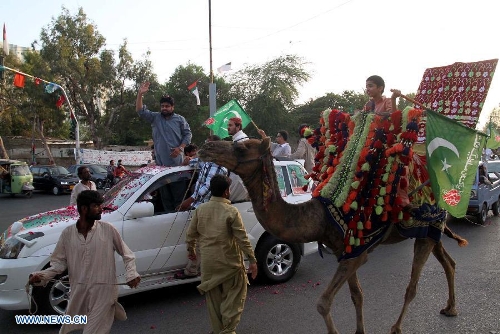 Supporters of Pakistan Muslim league Functional (PML-F) march on camel and car as part of an election campaign in southern Pakistani port city of Karachi on May 4, 2013. Pakistan is scheduled to hold parliamentary elections on May 11. (Xinhua/Arshad)