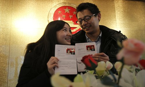 A couple gets their marriage certificates at Beijing Municipal Civil Affairs Bureau this December. Photo: CFP