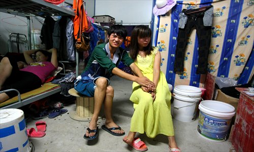 Wu Jianguo and his shy wife sit in the accomodation which they share with three other couples. Photo: Yang Hui/GT
