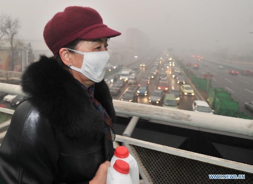 A citizen wearing mask walks on a bridge amid fog and smog in Tianjin, north China, Feb. 28, 2013. The fog hit Tianjin on Feb. 28 morning, causing heavy air pollution in the city. (Xinhua/Yue Yuewei) 
