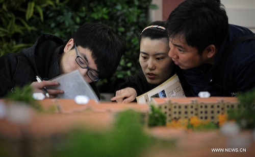 Visitors learn about housing information during the Spring Housing Fair in Shenyang, capital of northeast China's Liaoning Province, April 18, 2013. The housing fair provided 13,640 apartments and many housing projects offered promotional sale measures. (Xinhua/Yao Jianfeng) 