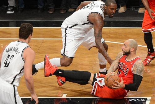 Chicago Bulls' Carlos Boozer (R) saves the ball during Game 7 of the NBA Eastern Conference Quarterfinals basketball playoff series against Brooklyn Nets in New York, the United States, May 4, 2013. Bulls won 99-93 Saturday to reach the second round with 4-3 in the first-round series. (Xinhua/Wang Lei) 