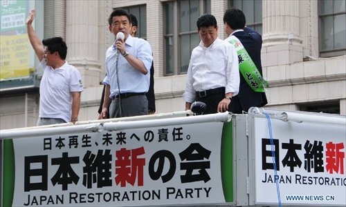 Osaka Mayor Hashimoto Toru (C, Front), who is also co-leader of the opposition Japan Restoration Party (JRP), speaks during a campaign in Osaka, Japan, July 4, 2013. Japan on Thursday officially kicked off the election campaign for the House of Councillors, the upper house in the Diet, with ruling coalition's vow to retake the chamber. Photo: Xinhua 