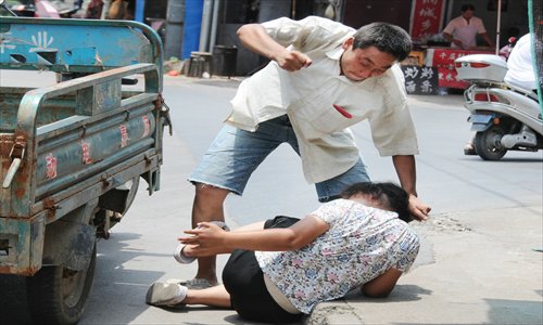 A man beats his wife in the street in  Jinhua, Zhejiang Province in 2011.  It is not known if the man was arrested. Photo: IC