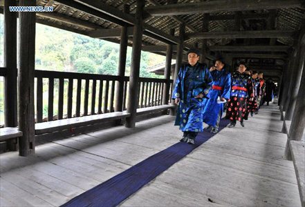 People of the Dong ethnic group walk through the Chengyang Fengyu Bridge during a celebration ceremony marking the 100th anniversary of its completion held in Sanjiang Dong Autonomous county, South China's Guangxi Zhuang Autonomous Region, December 1, 2012. Built in 1912, the 77.76-meter-long bridge is famed for its combination of bridge, veranda and Chinese pavilion. (Xinhua/Lai Liusheng) 


