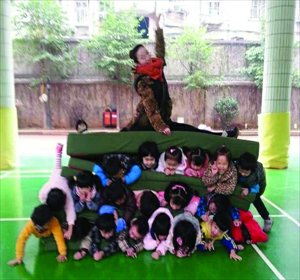 The teacher poses on top of the kids' human pyramid. Photo: Xiaoxiang Morning Post