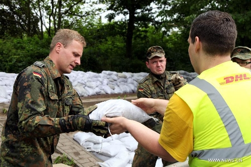 German Bundeswehr soldiers and local volunteers pass on sandbags to beef up the dike at Gimritzer Dammin in Halle, eastern Germany, on June 4, 2013. The water level of Saale River across Halle City is expected to rise up to its historical record of 7.8 meters in 400 years, due to persistent heavy rains in south and east Germany. (Xinhua/Pan Xu)&nbsp; 