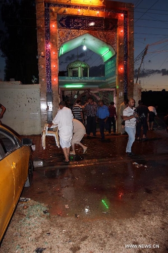 People clean the blast site at a Shiite mosque in Kirkuk, northern Iraq, May 16, 2013. At least 12 people were killed and 25 others injured as a suicide bomber blew himself up at a Shiite mosque in northern Iraq's Kirkuk on Thursday, local police sources said. (Xinhua/Dena Assad) 