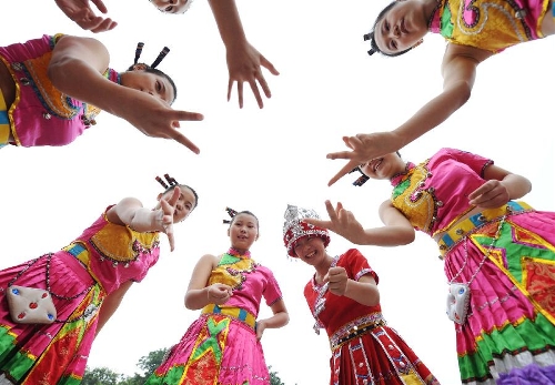 Girls in folk costumes perform for the opening of the China Tourism Day and the 3rd Western China Tourism Industry Expo, in Chongqing, southwest China, May 19, 2013. Chongqing is the main venue for the 2013 China Tourism Day. (Xinhua/Li Jian)