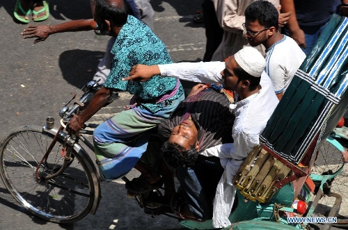 People carry an injured man by rickshaw during a grand rally at Motijheel area in Dhaka, Bangladesh, April 6, 2013. Tens of thousands of Islamists under the banner of Hefazat-e-Islam from across Bangladesh poured into the key commercial hub of the capital city to join a grand rally, demanding action against the 