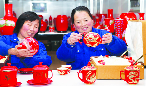 Employees at a ceramics painting plant in Miaocheng town, Beijing work on handicraft goods Wednesday. Local village women have become increasingly involved in the business of hand-made ceramic items as a way of boosting their income. The traditional products continue to be popular, both domestically and abroad. Photo: IC