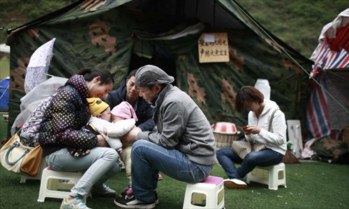 Parents play together with their children at a temporary settlement at the Hainan Middle School in quake-hit Baoxing county, Ya'an, Sichuan Province on April 24, 2013. A 7.0-magnitude earthquake jolted neighboring Lushan county in the morning of April 20, causing 193 deaths as of 6 pm on April 23. Photo: Li Hao/GT