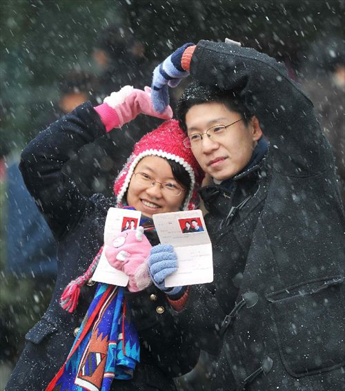 A couple showing their marriage certificates pose for a photo after registering in the marriage registration office in Changsha, capital of Central China's Hunan Province, January 4, 2013. Quite a number of couples flocked to tie the knot on January 4, 2013, or 2013/1/4, which sounds like 