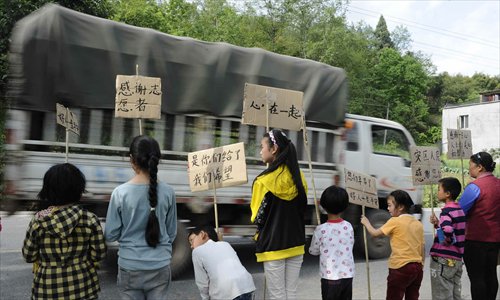 Students hold banners to express their gratitude to quake-relief workers along a road in Miaoxi village, Lushan county, Sichuan Province on April 24. Photo: Li Hao/GT